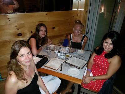 A group of friends on vacation eating at one of the best restaurants in the Hamptons. 