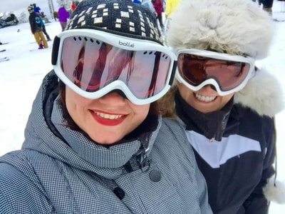selfie on the slopes. Girls from NYC  in coats and ski masks getting ready to ski. 