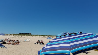 A striped umbrella on the beautiful private beach at the ocean vista hotel in the Hamptons. 