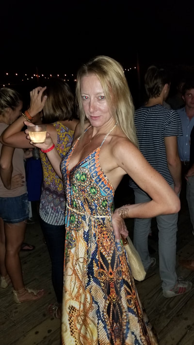 A woman with a drink in the Hamptons. 