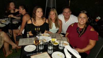 Young single NYC professionals enjoying dinner during their weekend vacation in the Hamptons. 