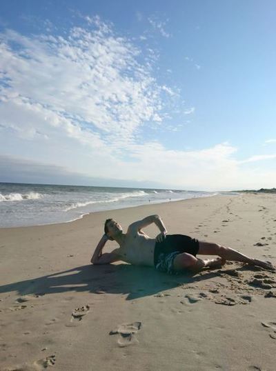 A man strikes a funny pose on a private beach in the Hamptons.