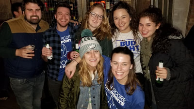 A group of friends with beers at a super bowl party in NYC. 